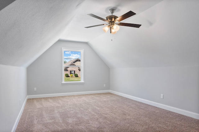 bonus room featuring carpet floors, a textured ceiling, vaulted ceiling, and ceiling fan