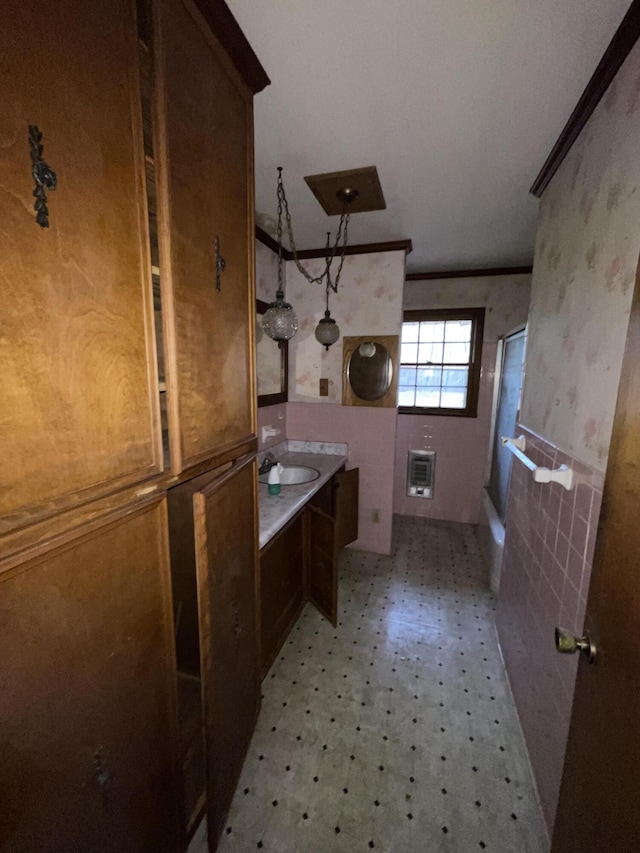 bathroom with a shower, vanity, and crown molding