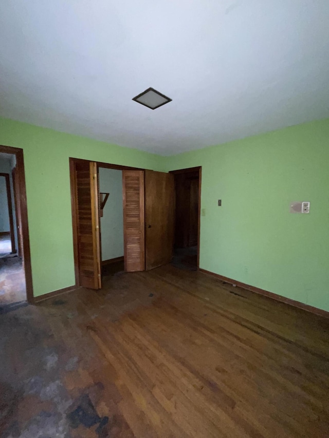 unfurnished bedroom featuring a closet and dark hardwood / wood-style flooring