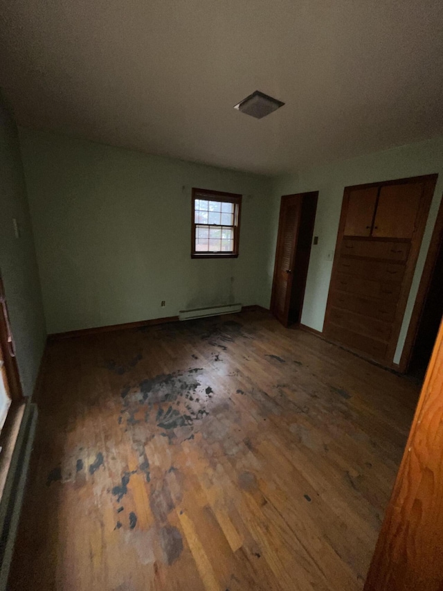 unfurnished bedroom with two closets and hardwood / wood-style flooring