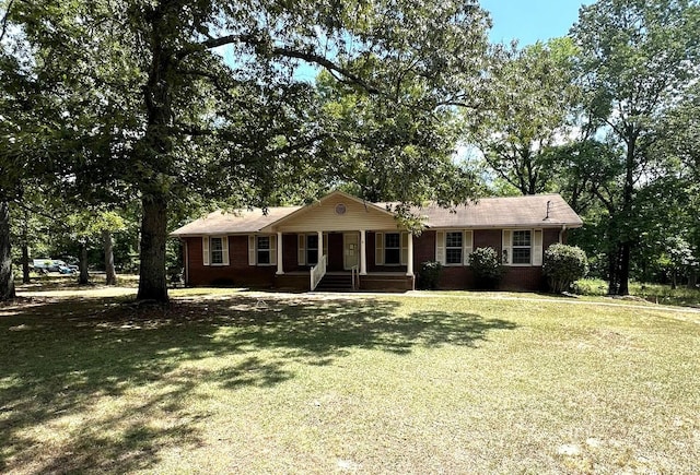 single story home featuring brick siding, a porch, and a front lawn