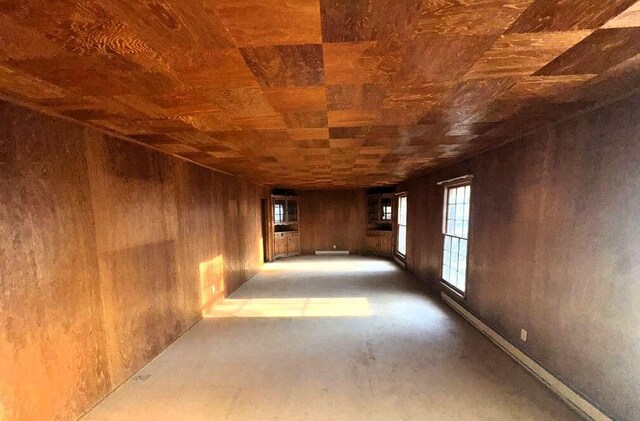 spare room featuring wooden ceiling and wooden walls