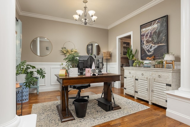 office space featuring wood-type flooring, an inviting chandelier, crown molding, and ornate columns