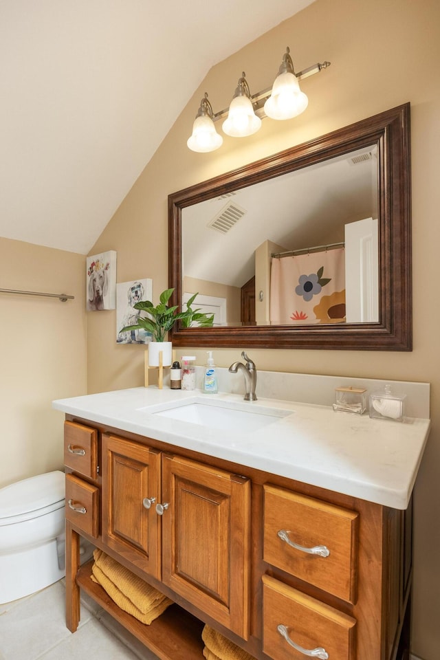 bathroom with vanity, vaulted ceiling, toilet, and tile patterned flooring