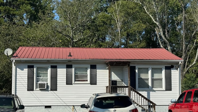 bungalow-style home with metal roof, crawl space, and cooling unit