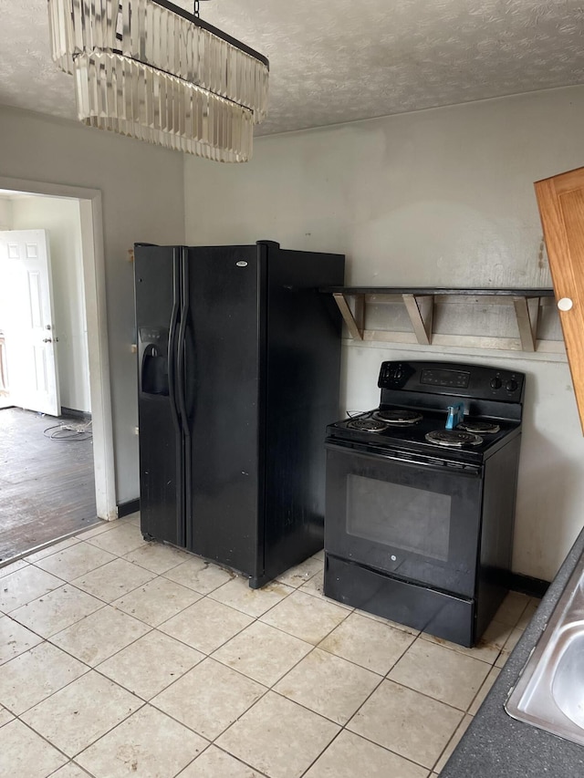 kitchen featuring a textured ceiling, black appliances, light tile patterned flooring, and a sink