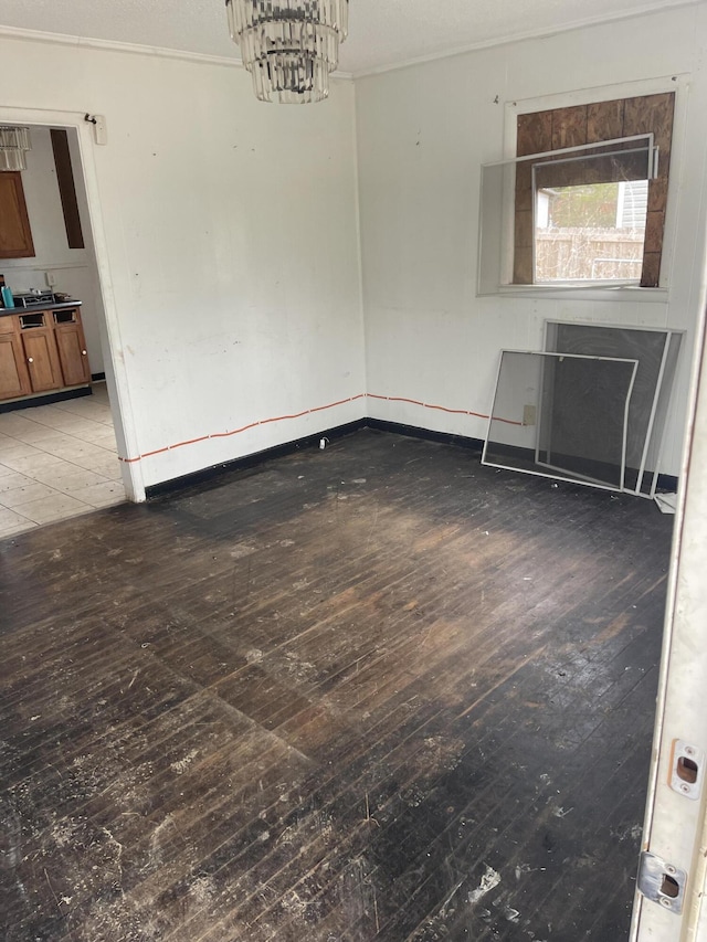 unfurnished room featuring an inviting chandelier and wood finished floors