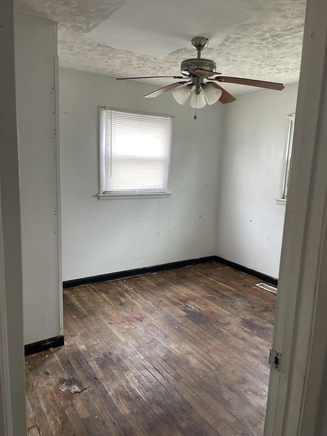 unfurnished room with baseboards and dark wood-type flooring