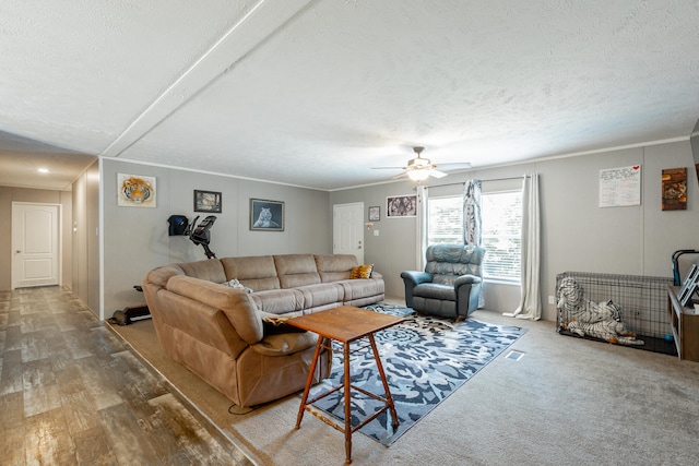 living room featuring hardwood / wood-style floors, ceiling fan, crown molding, and a textured ceiling