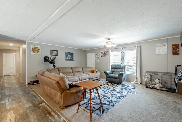 living room featuring a textured ceiling, ceiling fan, and ornamental molding