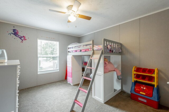 carpeted bedroom with a textured ceiling, crown molding, and ceiling fan