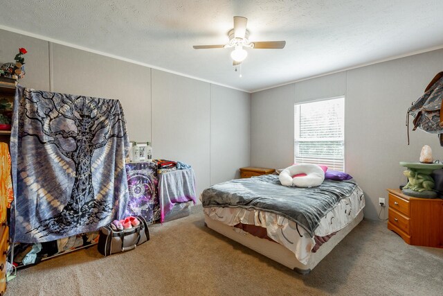 bedroom featuring a textured ceiling, crown molding, ceiling fan, and carpet floors