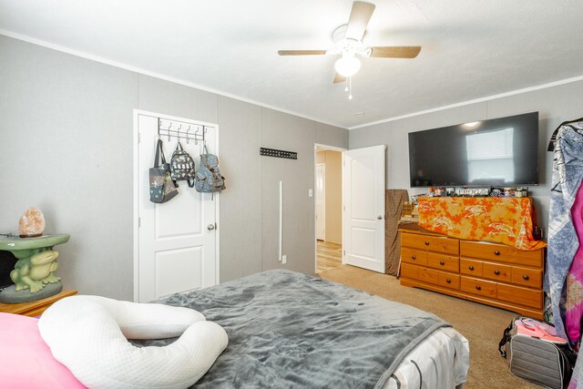 bedroom featuring ceiling fan, light colored carpet, and ornamental molding