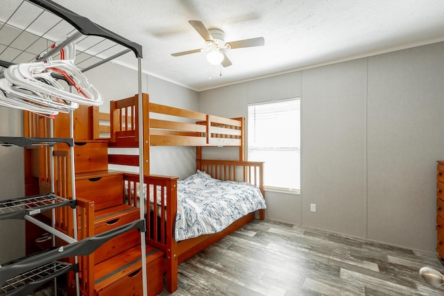 unfurnished bedroom with wood finished floors, ceiling fan, ornamental molding, and a textured ceiling