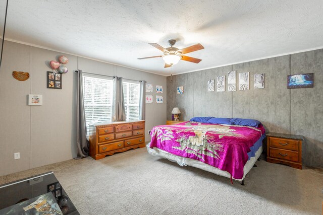 carpeted bedroom featuring a textured ceiling, ceiling fan, and ornamental molding