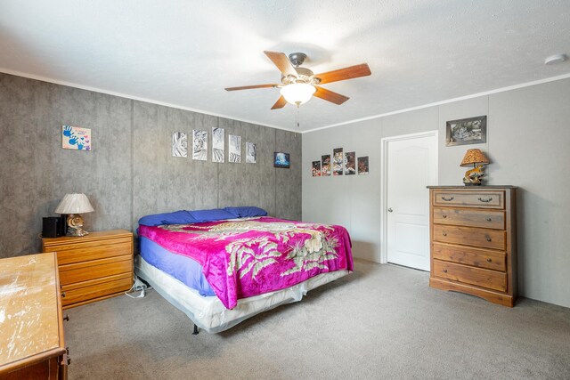 carpeted bedroom featuring ornamental molding and ceiling fan