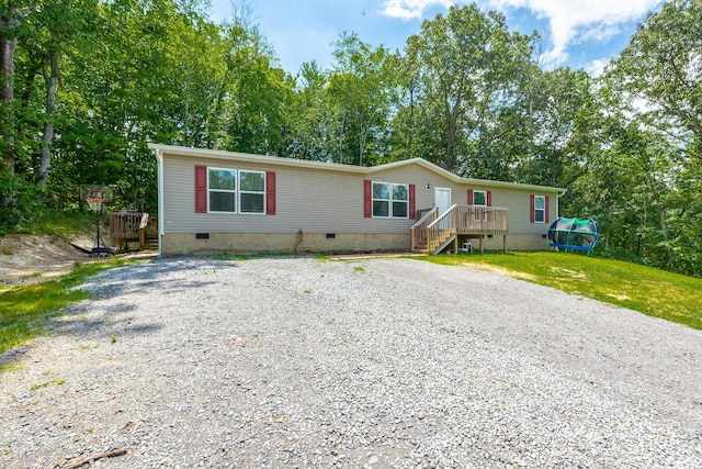 manufactured / mobile home with driveway, crawl space, and a front lawn
