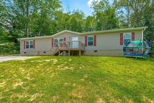 manufactured / mobile home with a front yard, stairway, a trampoline, a wooden deck, and crawl space