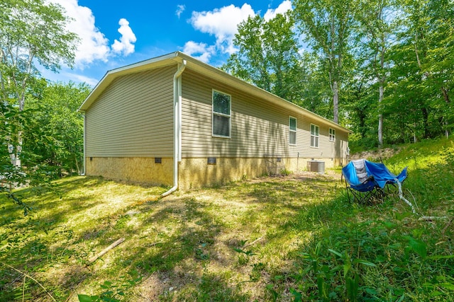 view of home's exterior with crawl space and central AC unit