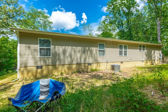 rear view of property featuring crawl space and cooling unit