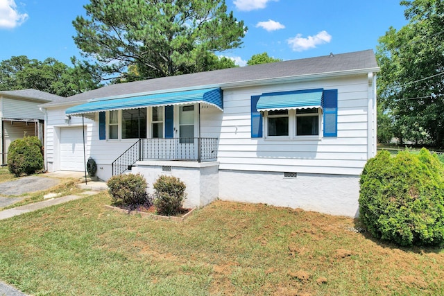 ranch-style home featuring a garage, a front lawn, and covered porch