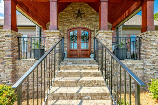 entrance to property featuring french doors and stone siding