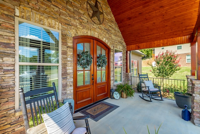 doorway to property featuring a porch and french doors