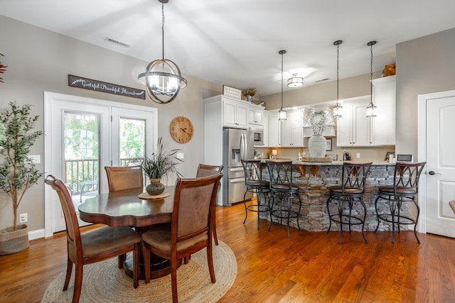 dining room with wood-type flooring and a chandelier