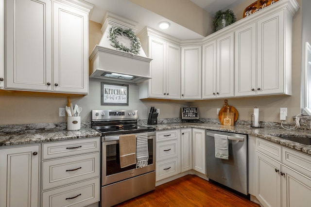 kitchen featuring appliances with stainless steel finishes, light stone countertops, white cabinets, and dark hardwood / wood-style floors