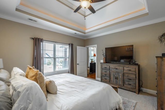 bedroom with a tray ceiling, crown molding, and ceiling fan