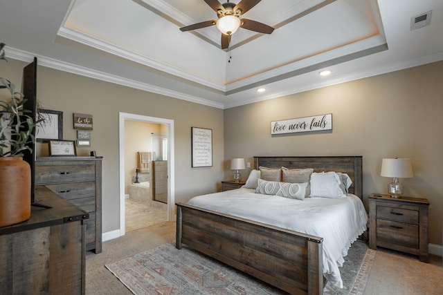 carpeted bedroom featuring ensuite bath, crown molding, a tray ceiling, and ceiling fan