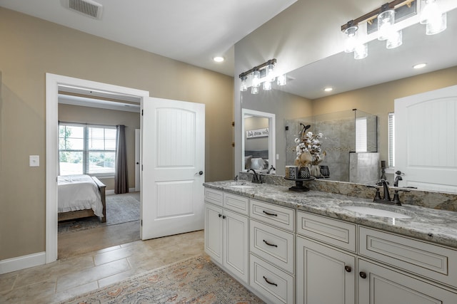 bathroom featuring tiled shower, vanity, and tile patterned floors