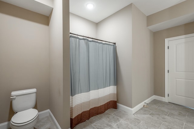 bathroom featuring walk in shower and toilet