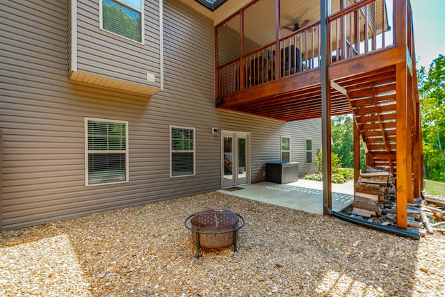 exterior space with an outdoor fire pit, a wooden deck, and a patio