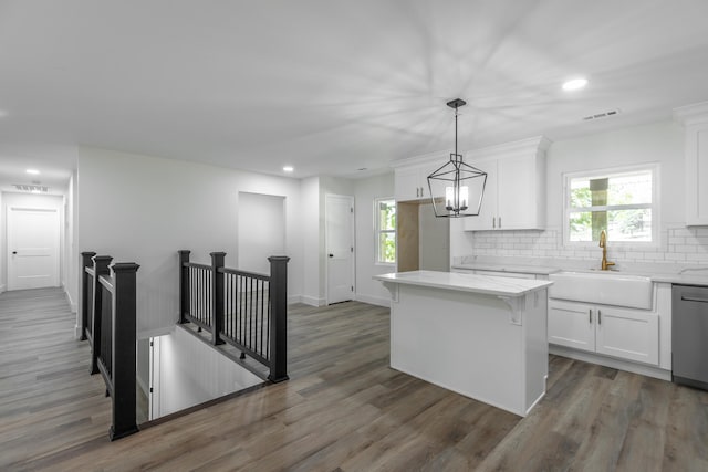 kitchen featuring dishwasher, a center island, white cabinetry, sink, and dark wood-type flooring