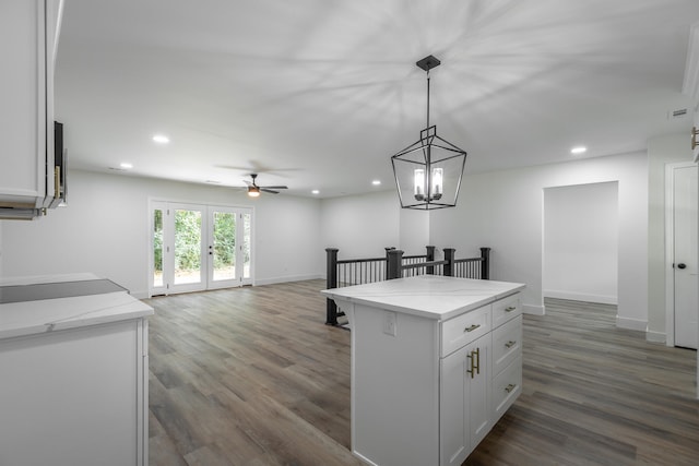 kitchen featuring dark wood-type flooring, white cabinetry, and light stone countertops