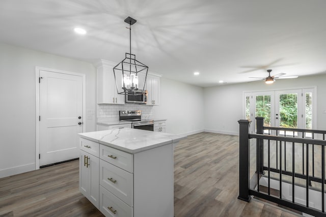 kitchen with ceiling fan with notable chandelier, stainless steel appliances, white cabinetry, dark wood-type flooring, and tasteful backsplash