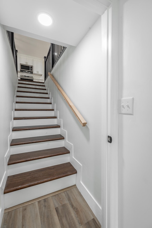 staircase with hardwood / wood-style floors