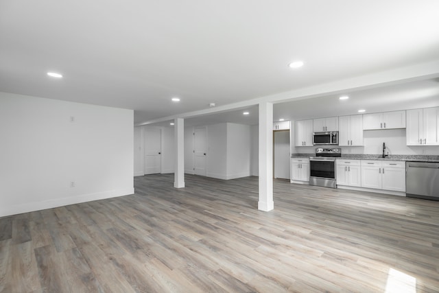 unfurnished living room with light wood-type flooring and sink