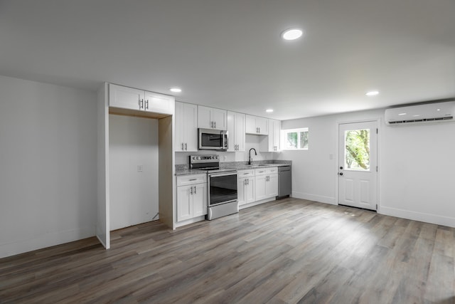 kitchen featuring hardwood / wood-style floors, sink, light stone countertops, appliances with stainless steel finishes, and white cabinets