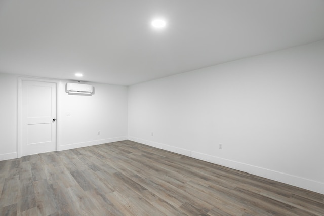 empty room with hardwood / wood-style flooring and a wall mounted air conditioner