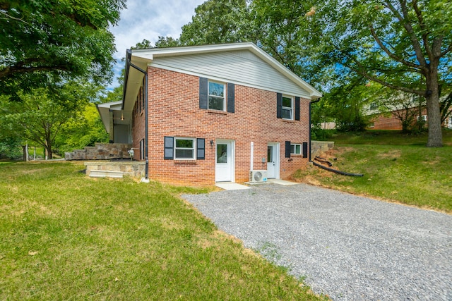 view of front facade featuring a front lawn and ac unit