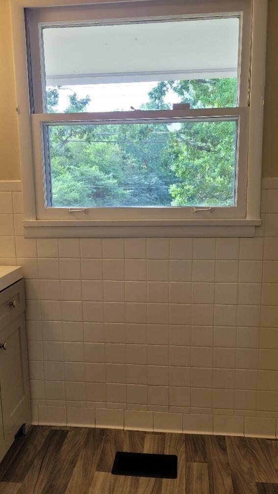 bathroom featuring tile walls, hardwood / wood-style flooring, and vanity