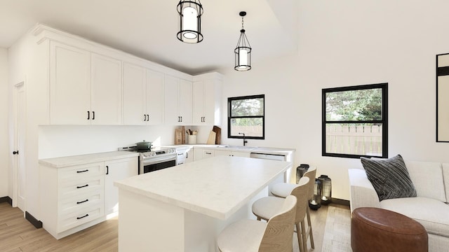 kitchen featuring pendant lighting, light hardwood / wood-style flooring, a wealth of natural light, and electric stove