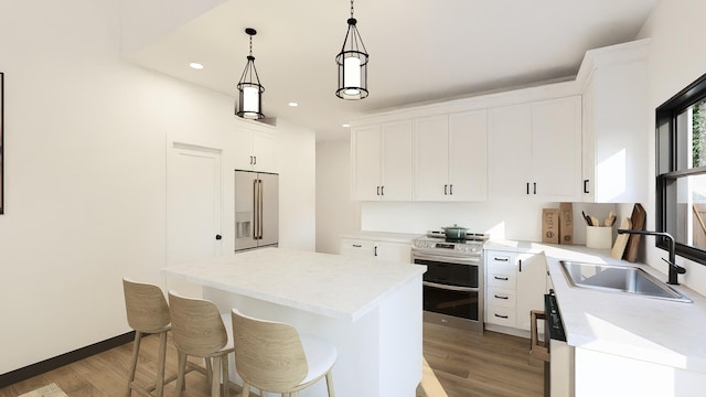 kitchen with white cabinetry, sink, a center island, decorative light fixtures, and appliances with stainless steel finishes