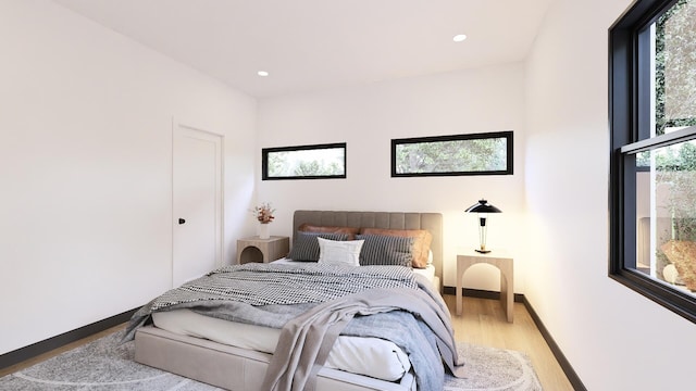 bedroom with hardwood / wood-style flooring and multiple windows