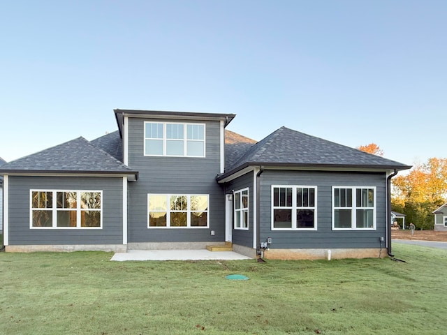 back of house with a patio and a lawn