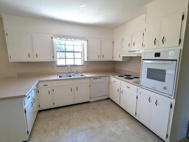 kitchen with white appliances, sink, white cabinets, and a textured ceiling