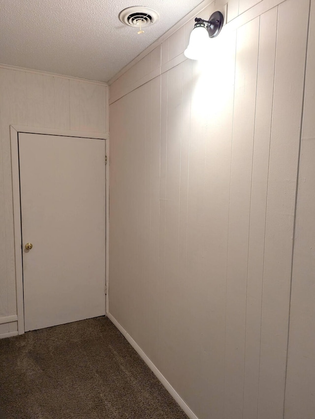 interior space featuring a textured ceiling and carpet flooring