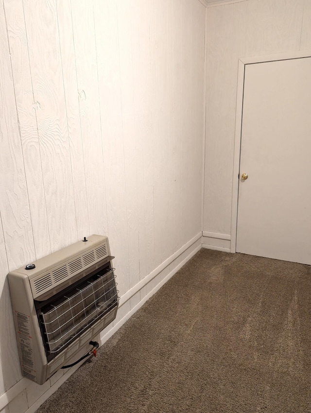 unfurnished room featuring heating unit and carpet flooring